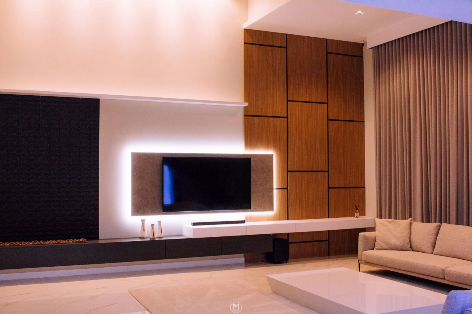Sala com painel amadeirado, televisão e iluminação indireta